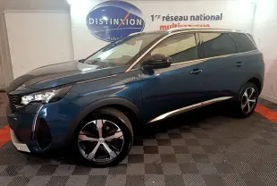 Vue de profil côté gauche d'un Peugeot 5008 bleu avec jantes alliage et vitres teintées dans un showroom intérieur.