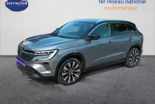 Renault Austral gris schiste métal en 3/4 avant droit, avec jantes alliage bicolores et calandre distinctive.