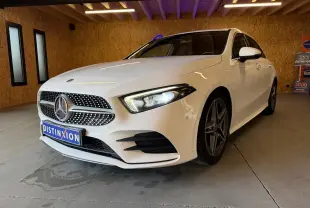 Vue 3/4 avant droite d'une Mercedes Classe A 220D AMG Line blanche avec calandre diamant et jantes AMG foncées.